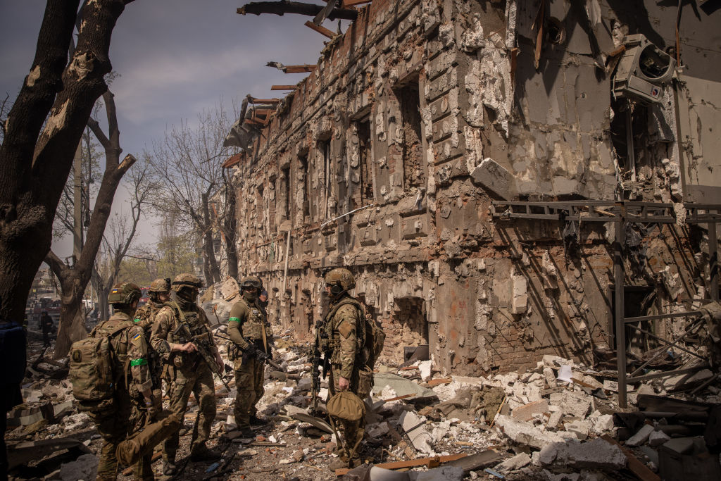 Shopping de Kharkiv destruído após bombardeio russo. Soldados ucranianos investigam o cenário