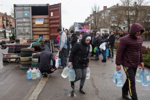 Pessoas se reunindo ao redor de um caminhão para buscar água na cidade de Mykolaiv. A cidade está sendo bombardeada desde o início da guerra na Ucrânia e o governador diz que está disposto a pagar 100 dólares para quem ajudar na "caça" aos espiões que ele acredita haver.
