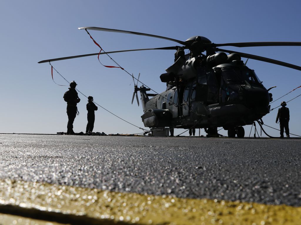 Helicóptero das forças armadas com soldados ao redor