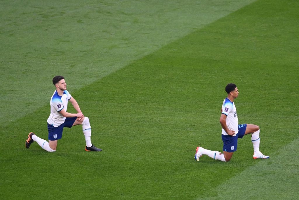 Jogadores ingleses se ajoelham antes da partida em protesto ao racismo. A Fifa havia vetado o uso da braçadeira "One Love", com cores do arco-íris contra as leis anti-LGBTQIA+ do Catar.
