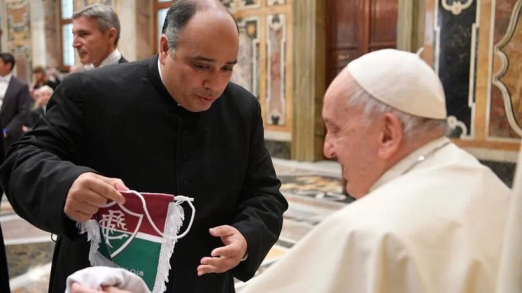 Papa Francisco sorri ao ganhar camisa e flâmula do Fluminense por padre carioca